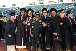 Students in black cap and gowns graduating.