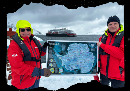 Professor Eric Eckert and shipmate holding up map with his students' signatures on it.