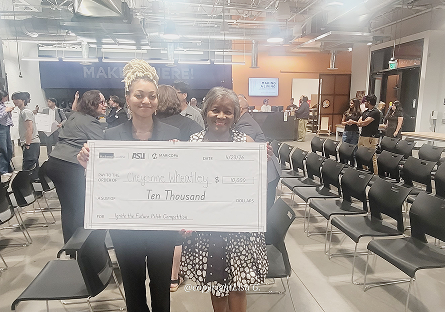 Cheyenne and her relative holding the large paper check together