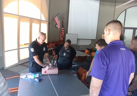 A paramedic shows EMCC employees how to use a tourniquet to stop the bleed.
