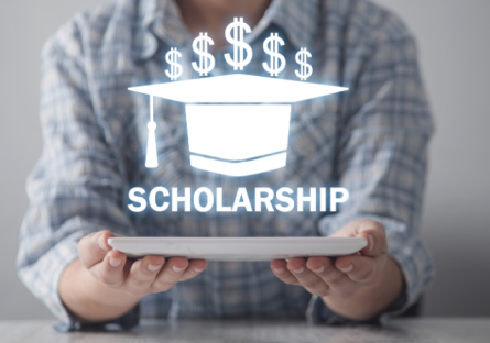 person holding graduation cap drawing that says scholarships