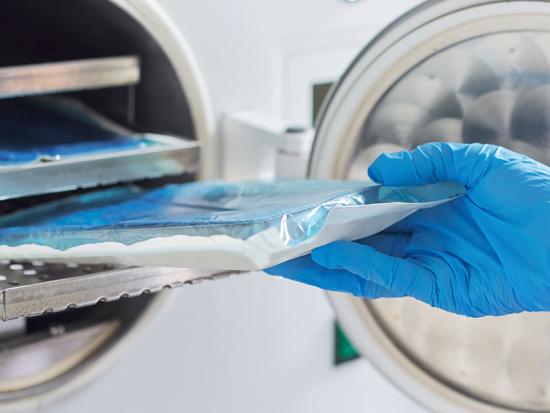 Person pulling medical samples out of a piece of equipment