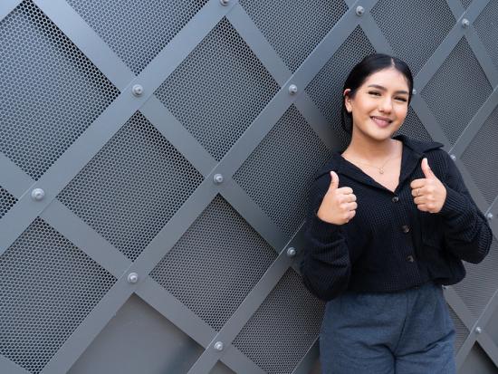 student giving a double thumbs up