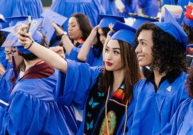 Students celebrating at graduation taking a selfie
